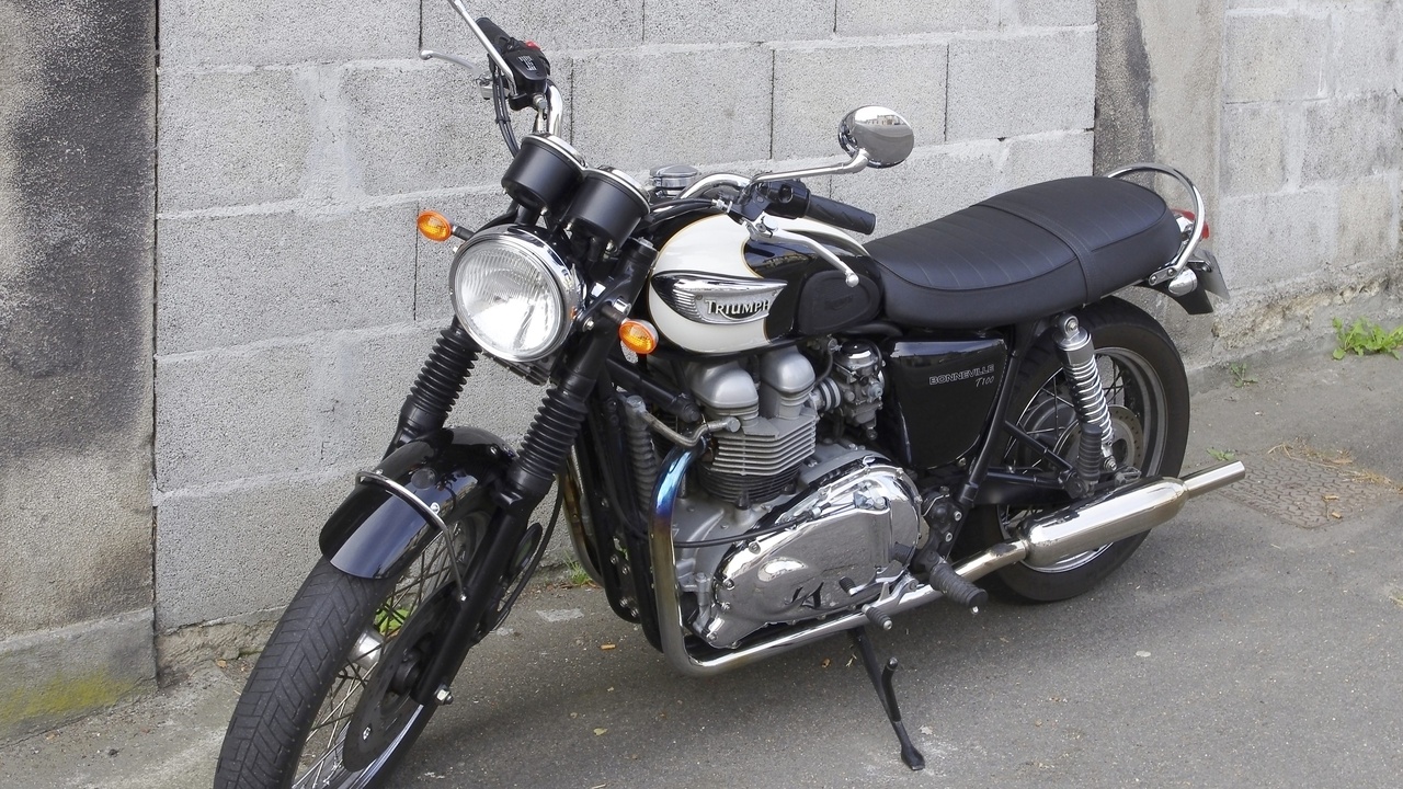 Triumph Bonneville 2012 in classic finish parked by a cafe.