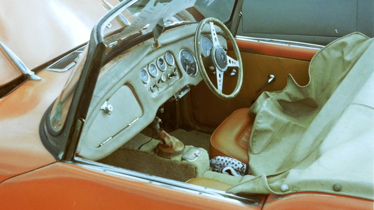 1965 Jaguar E-Type and 1965 Porsche 911 parked by a country road