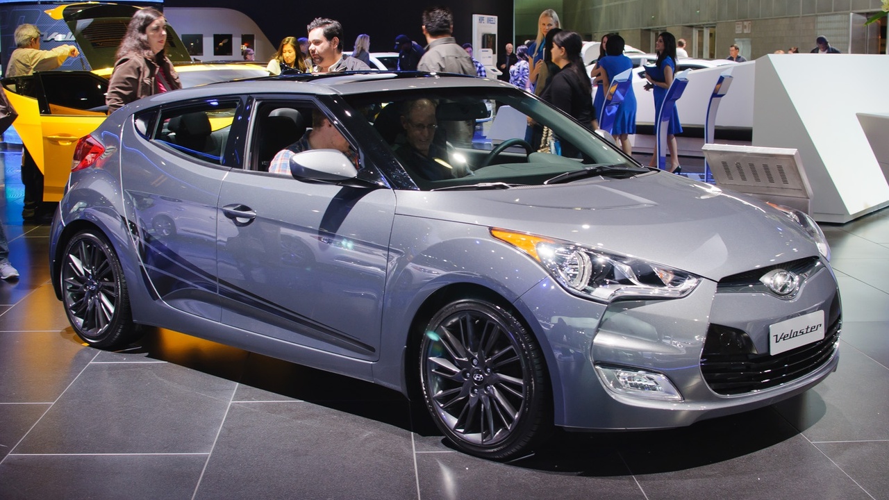 Two-door coupe parked on a rainy street protecting occupants