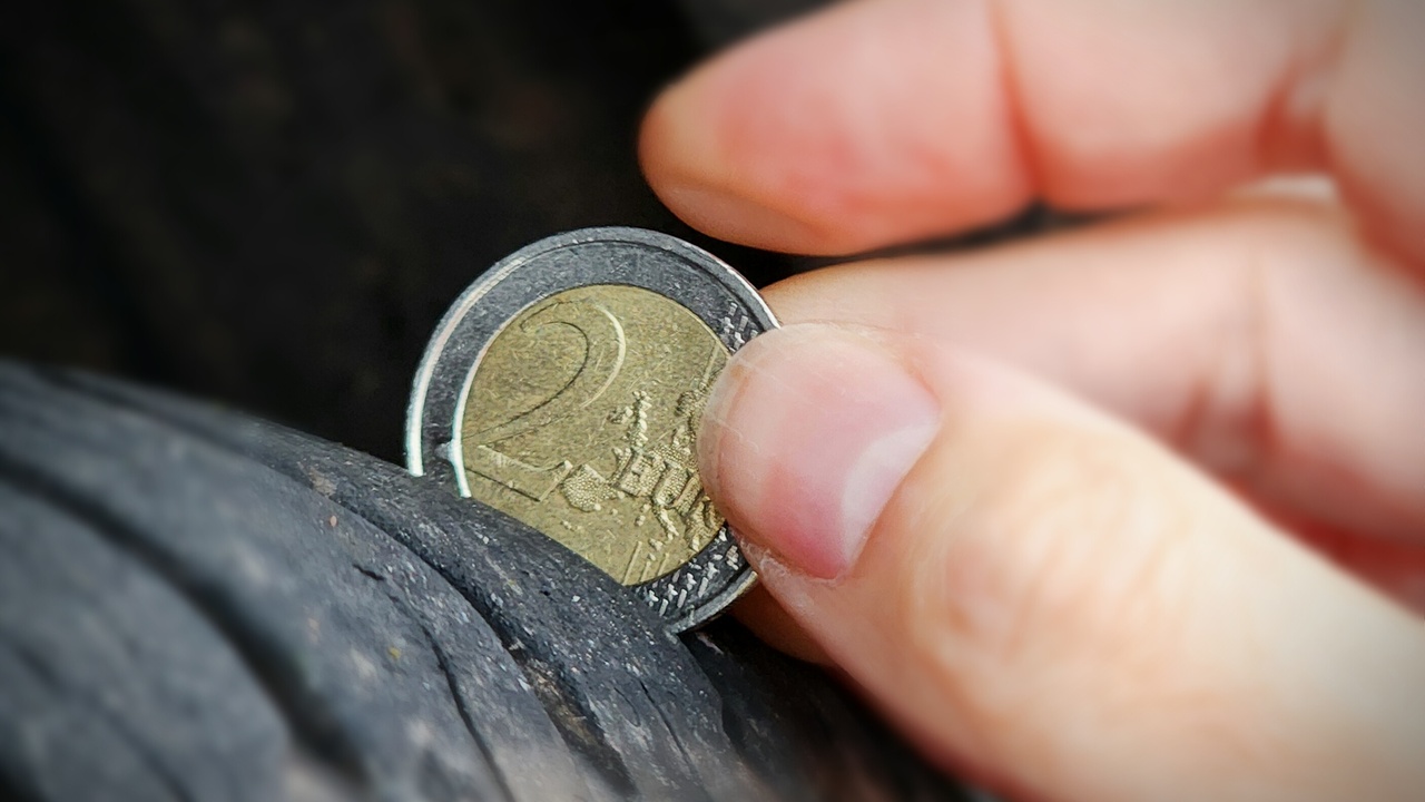 Car on snowy road with close-up of winter tire tread