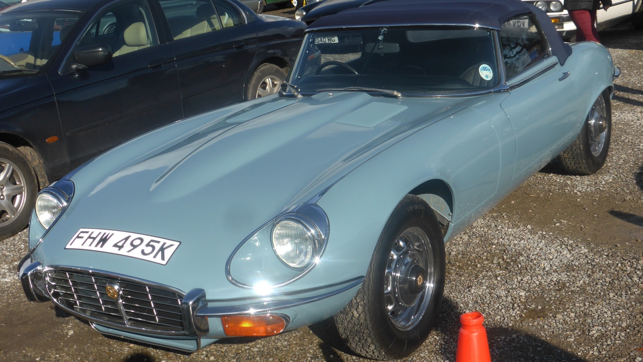 Two-door coupe in a driveway showing clean roofline and styling