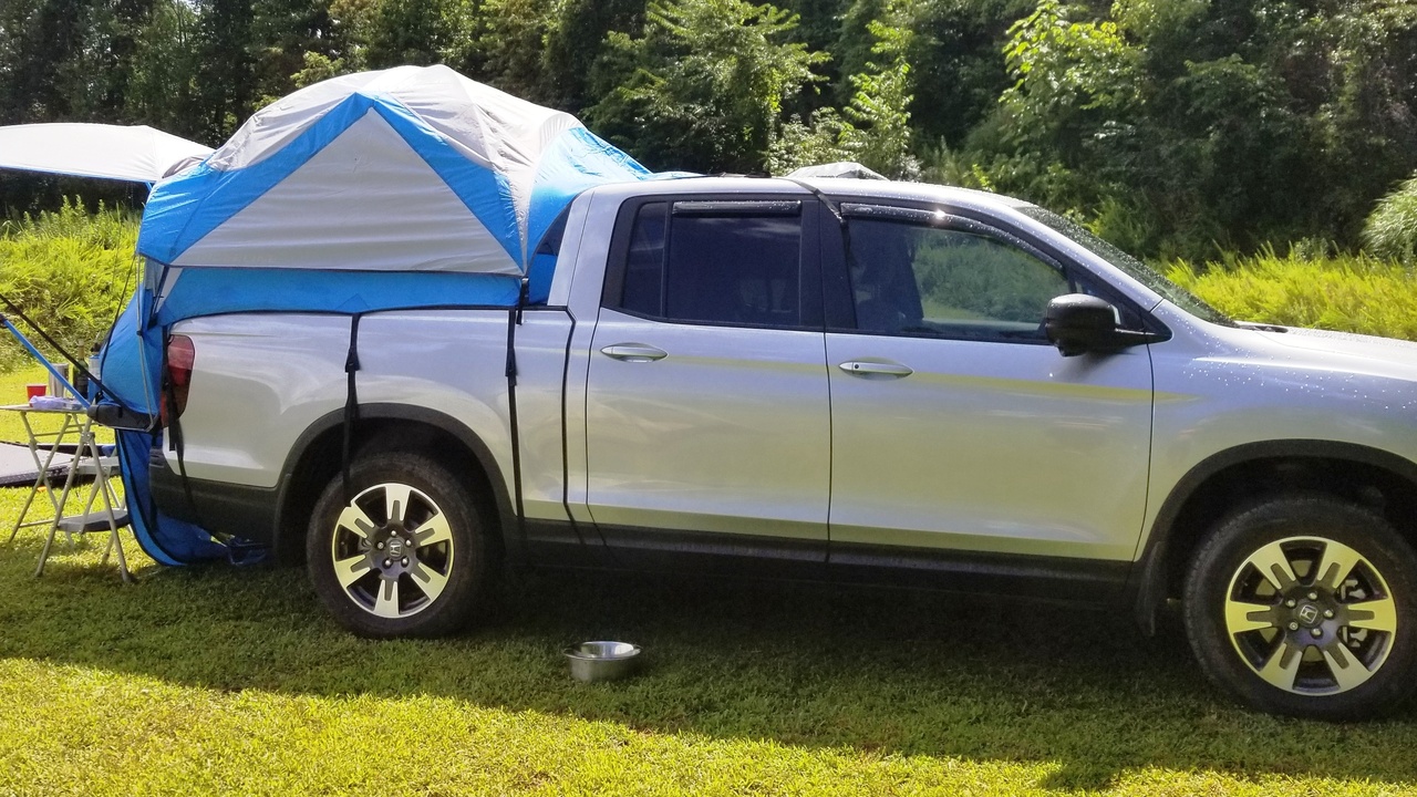 Honda Ridgeline truck bed open and Honda Passport parked near a trailhead.
