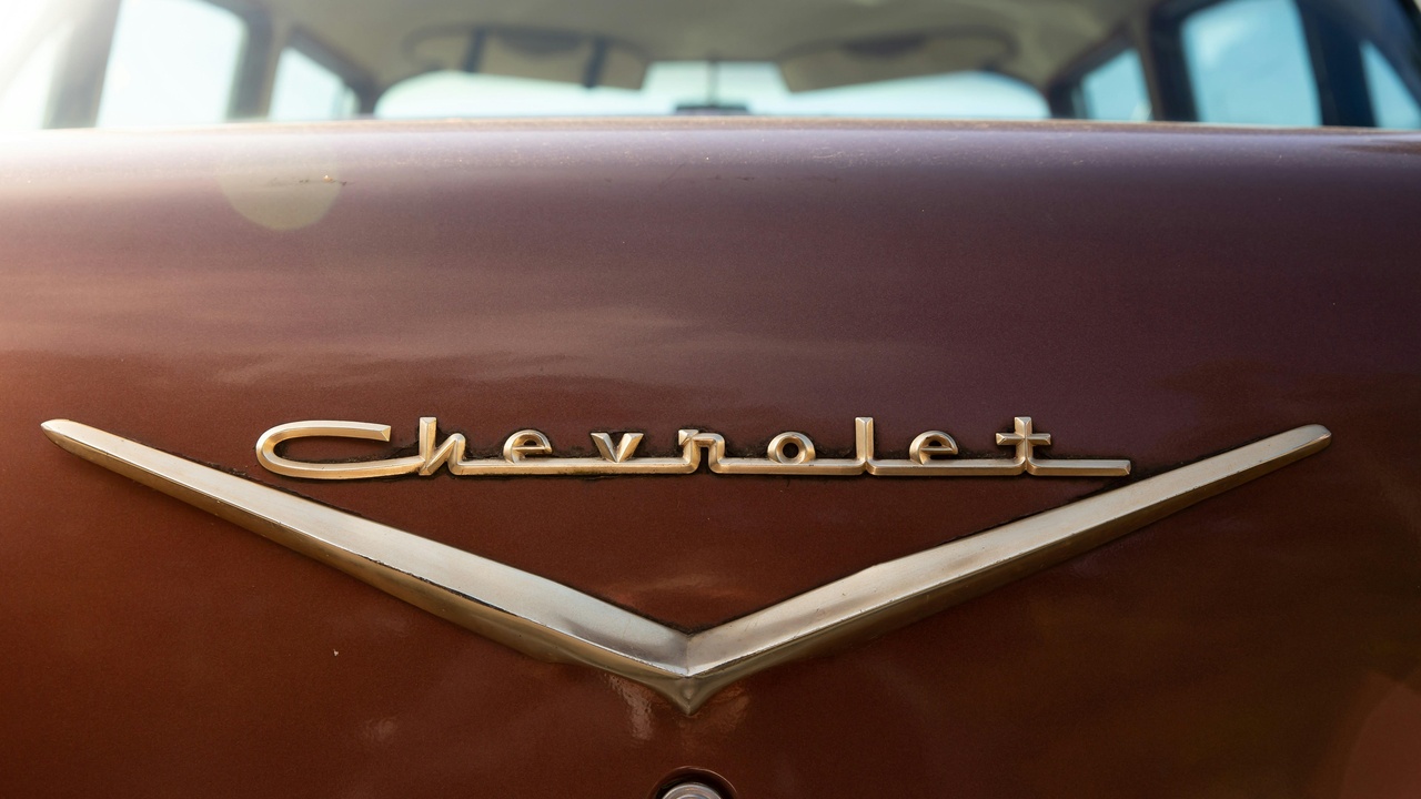 1941 Chevrolet Special Deluxe and Ford Super Deluxe family sedans parked on a suburban street, showcasing rounded fenders and chrome details