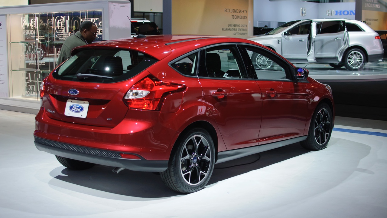 Fuel pump and hatchback in driveway representing cost and efficiency