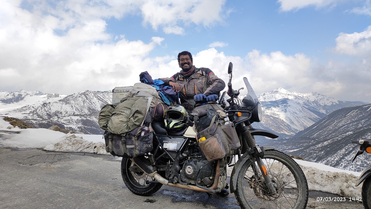 Adventure motorcycle loaded with panniers on a paved road, showing luggage and rugged tires