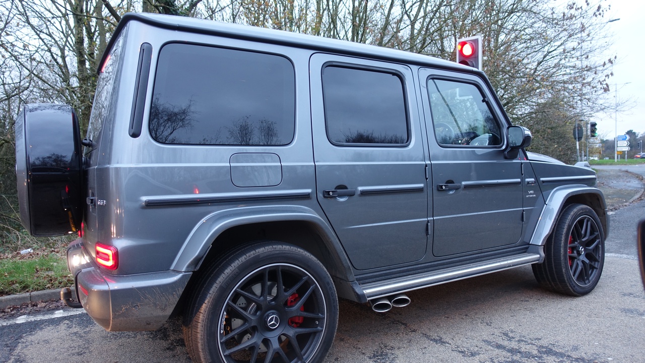 Driver focused on the road with automatic gear selector visible, highlighting reduced distraction.