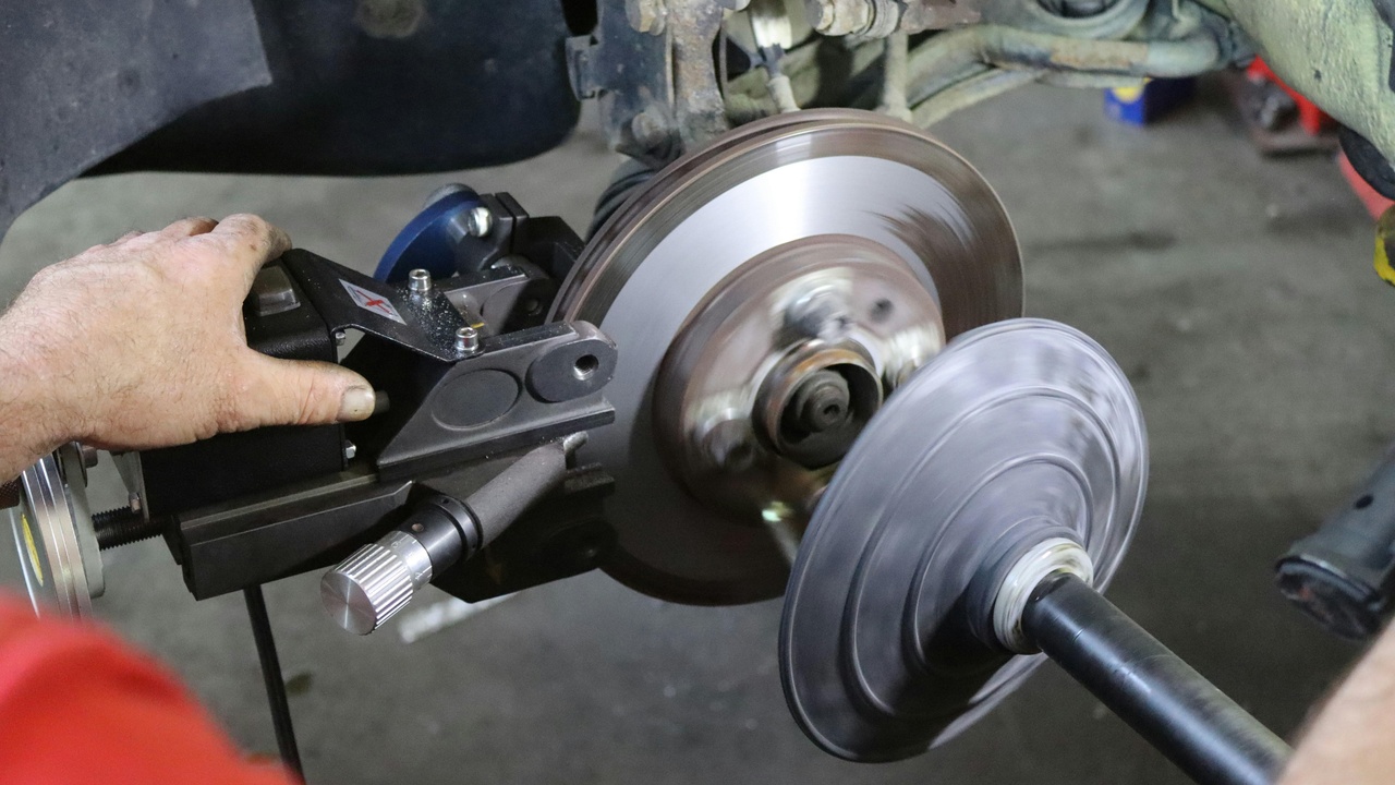 Close-up of a multi-piston performance caliper and oversized rotor showing brake components that improve stopping performance.