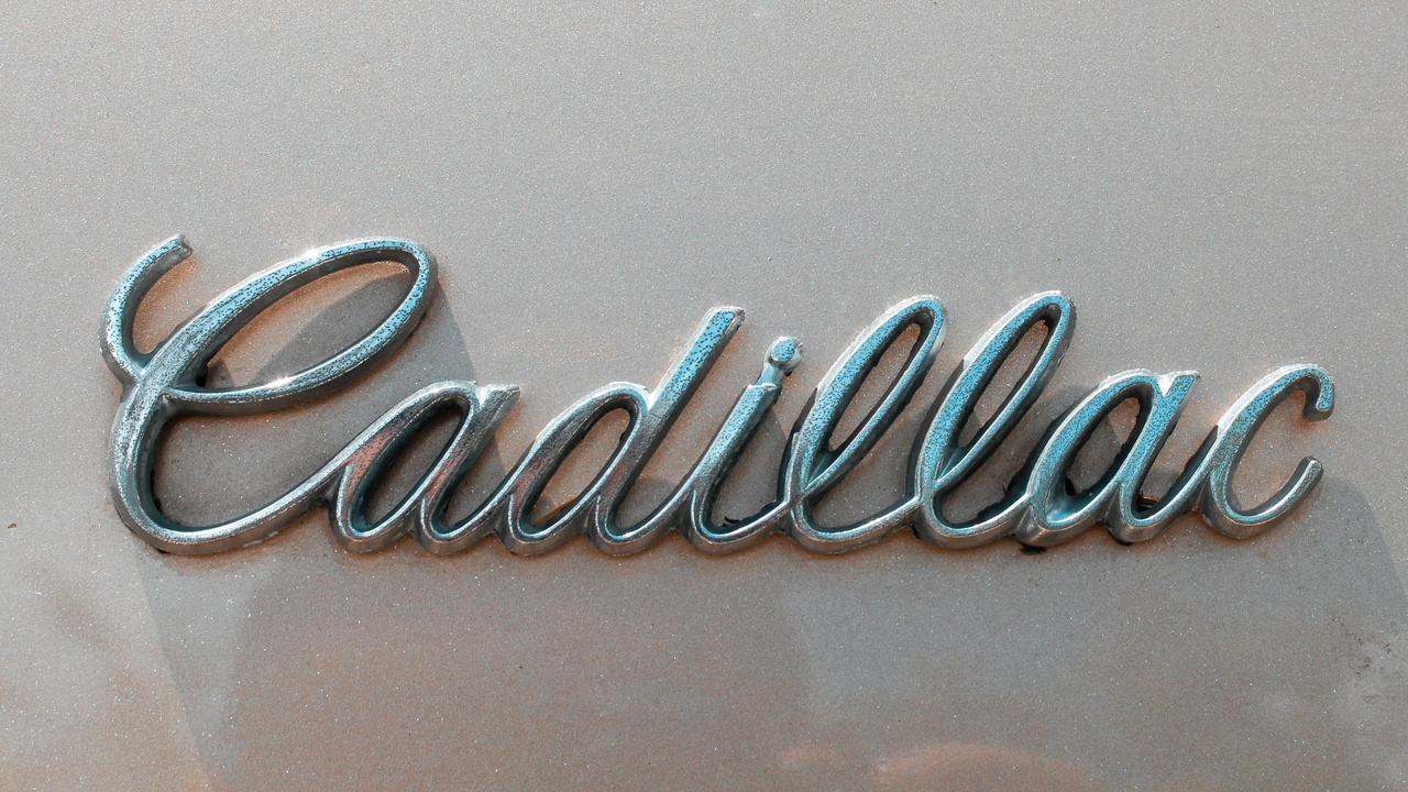 Technician inspecting Cadillac HVAC system and interior trim