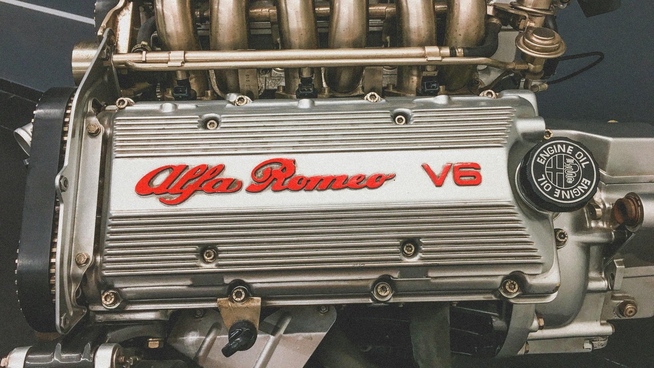 Mechanic working on inline-six engine head illustrating maintenance advantages