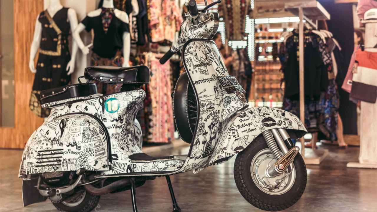 Rider maneuvering a small moped through city traffic