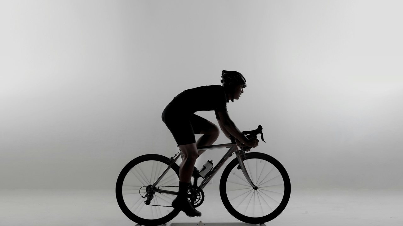 Rider in a tucked sport position behind a full fairing on a highway showing aerodynamic posture.