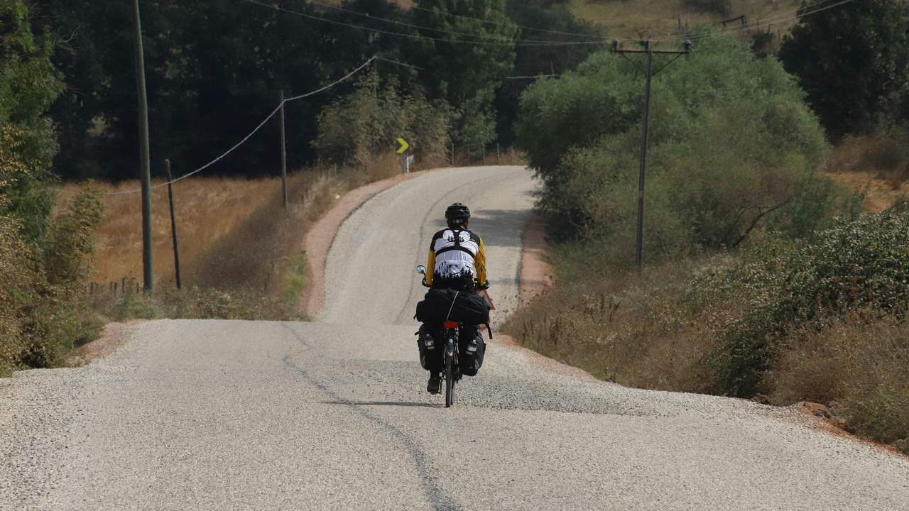 Rider on a sport-touring motorcycle with tall windscreen and comfortable seat on a highway