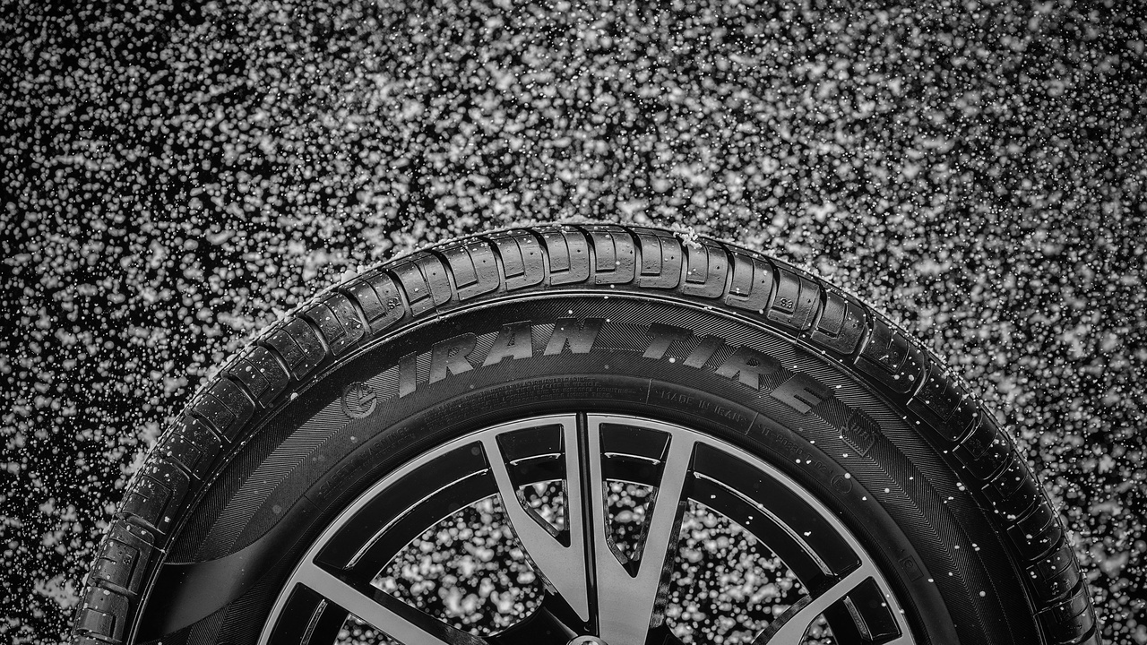 Driver checking tires while parked, showing tire sidewalls and tread