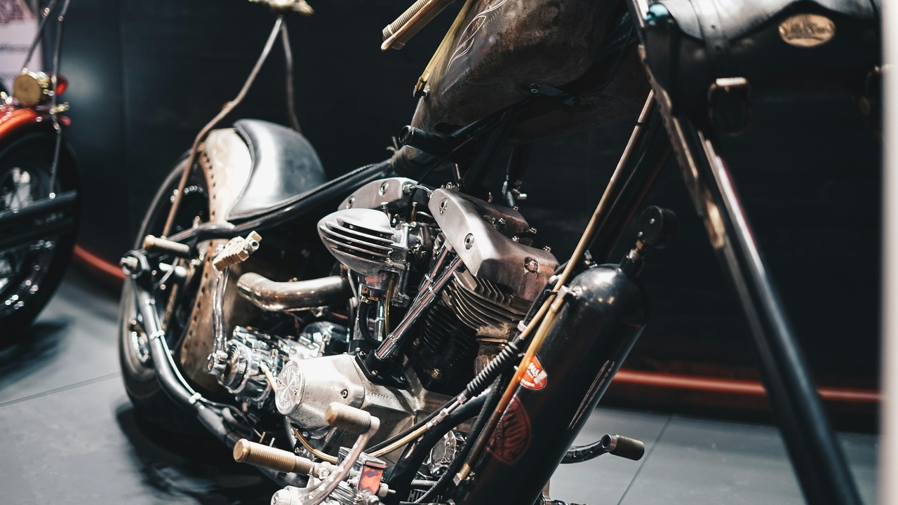 Custom choppers on display at a motorcycle rally with crowds and maker booths