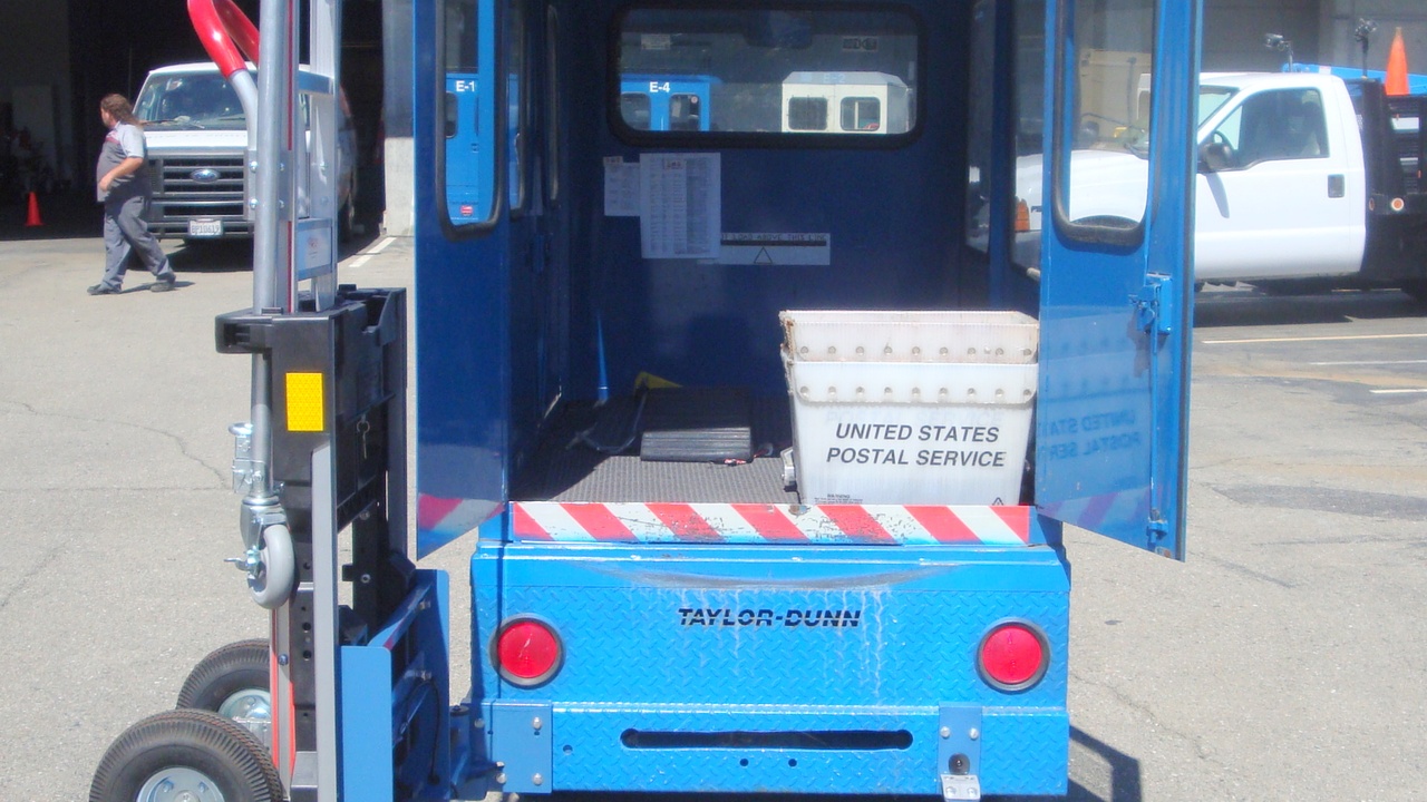 Delivery cargo van at a loading dock with organized shelving and boxes ready for routes