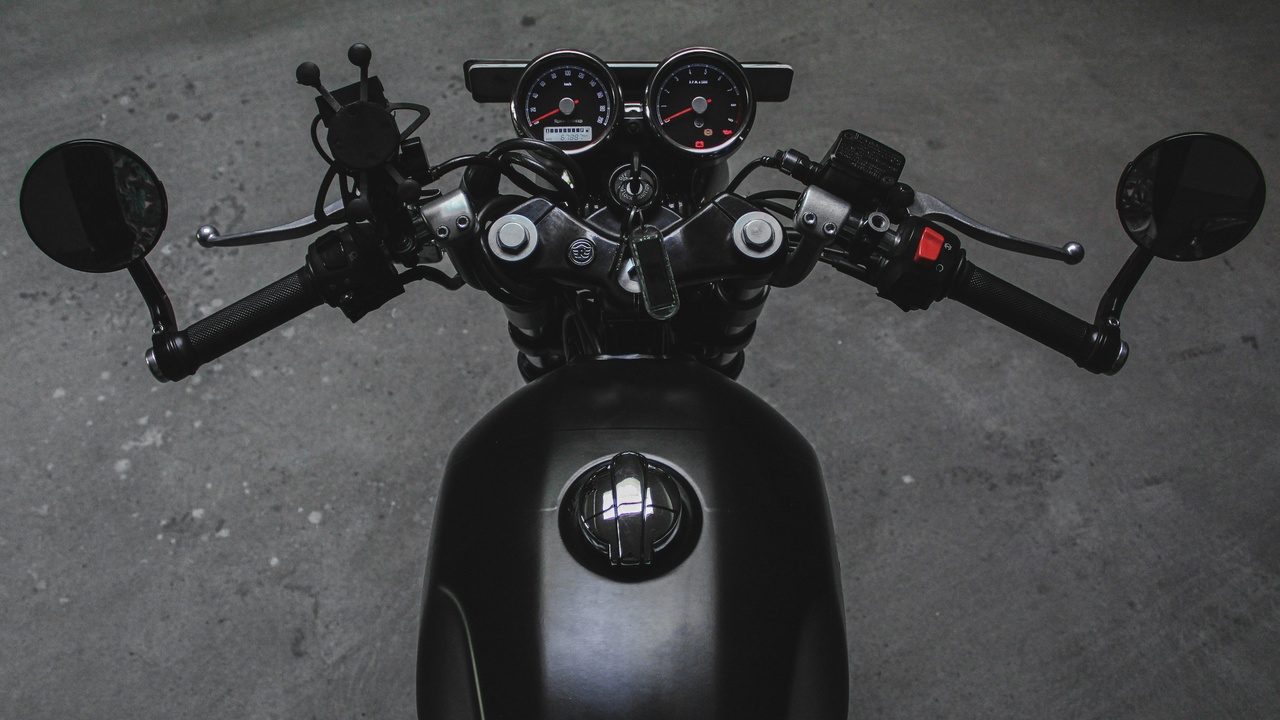 A 2021 naked motorcycle parked in an urban setting with a commuter helmet