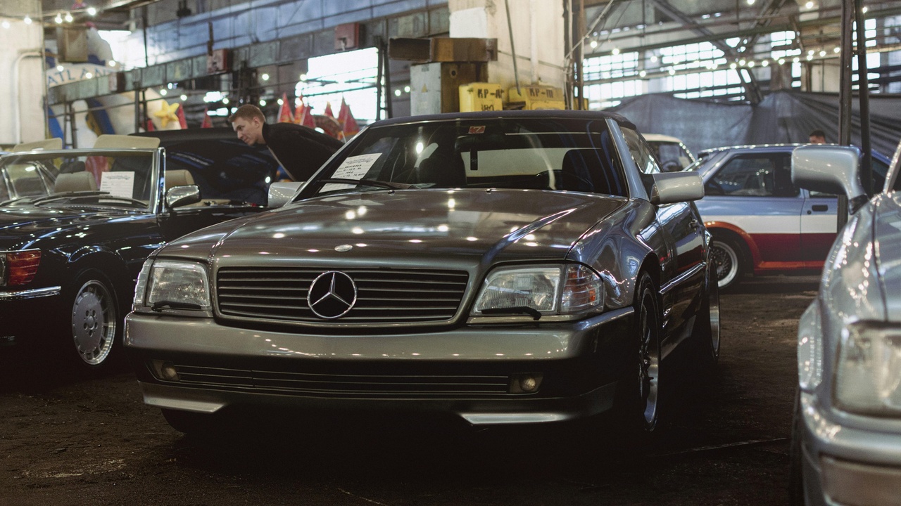 A 1982 Mercedes-Benz 380SL convertible with leather interior at a scenic overlook