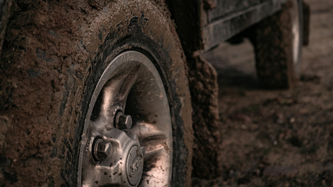 Car stopping on a wet, cool road showing tire tread and water spray