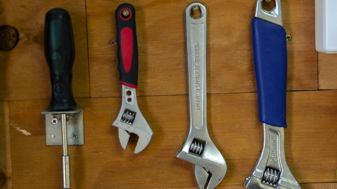 Tools and a sway bar removed from a car, showing bushings and end-links; illustrates installation and common replacement parts.