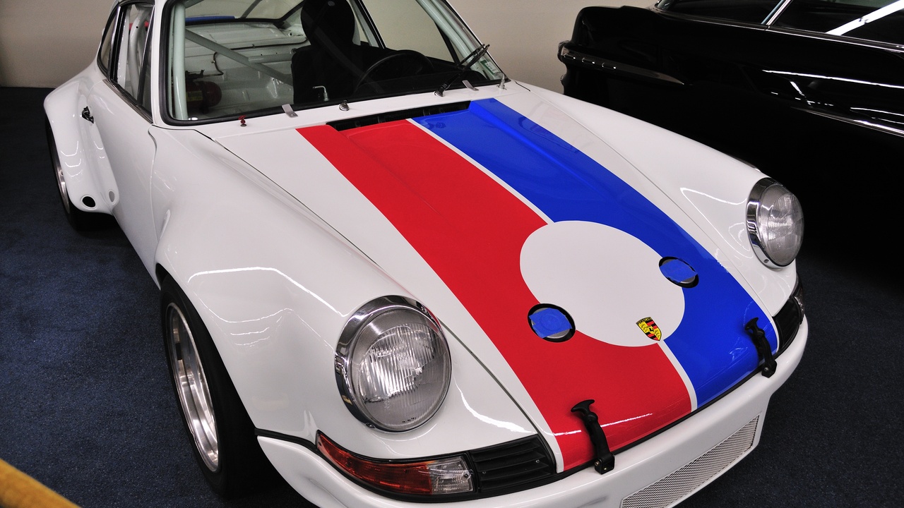 Porsche 911 on a racetrack with focus on driver cockpit and car dynamics.