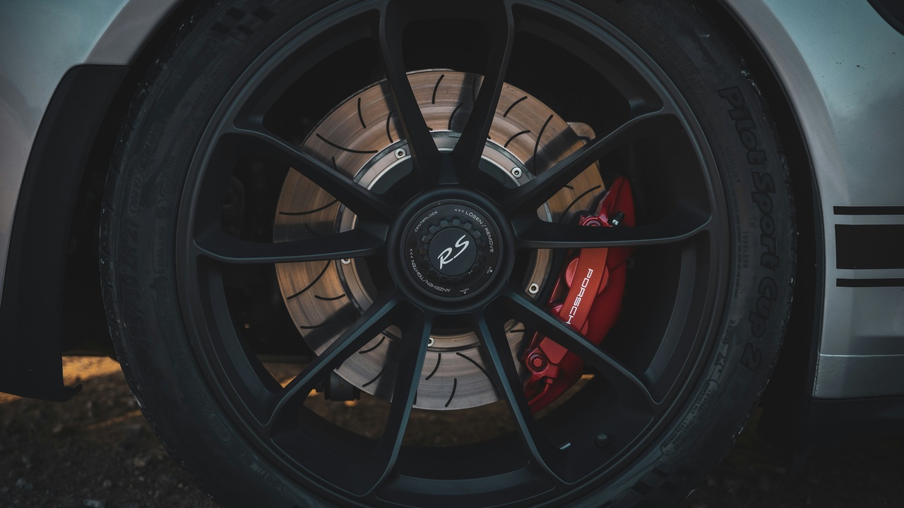 Forged alloy wheel on track with visible spokes and brake rotor, illustrating performance and handling benefits