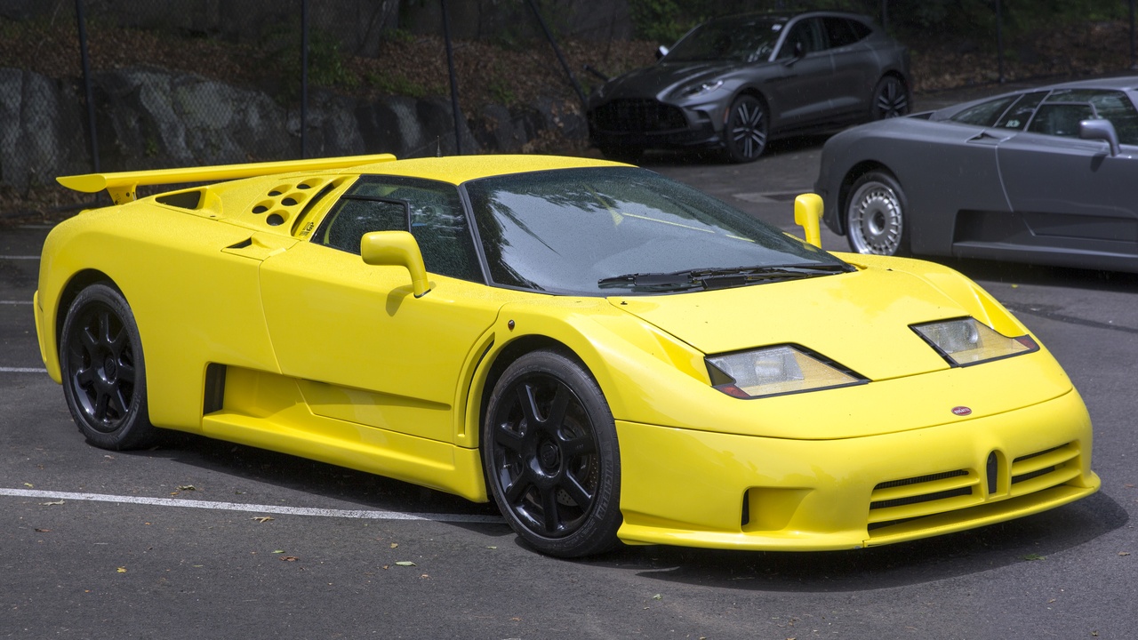 Three 1990s sports cars parked: Toyota Supra MK4, Chevrolet Corvette C5, Mazda RX‑7