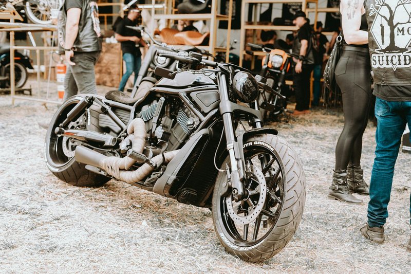 A custom motorcycle showcased at an outdoor bike event with people in the background.