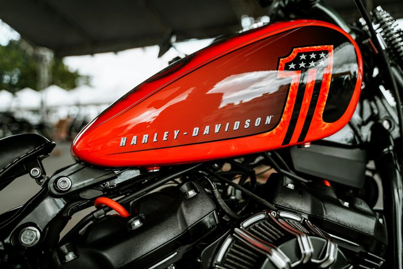 Close-up of a vibrant red Harley-Davidson motorcycle tank. Perfect for automotive enthusiasts.