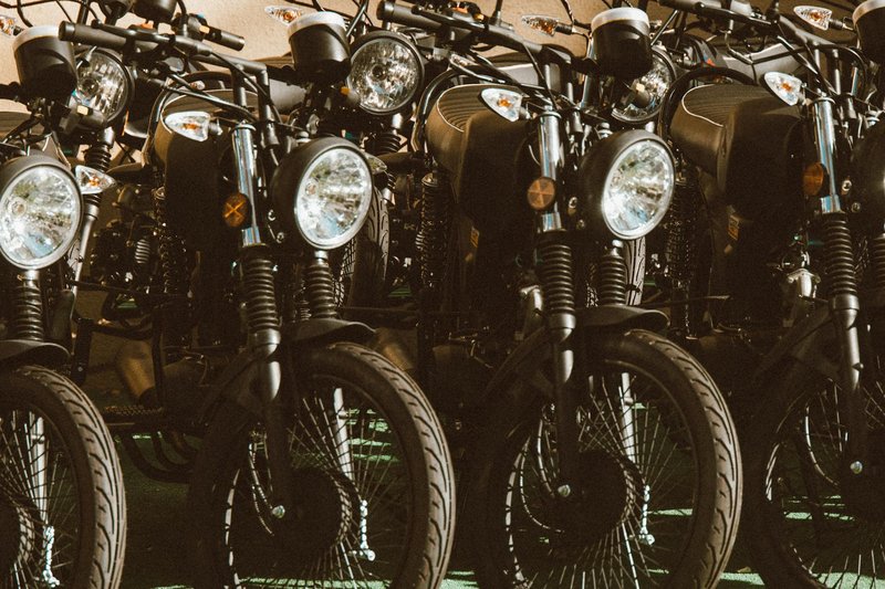 A stylish lineup of vintage motorcycles parked in a sunlit outdoor setting.