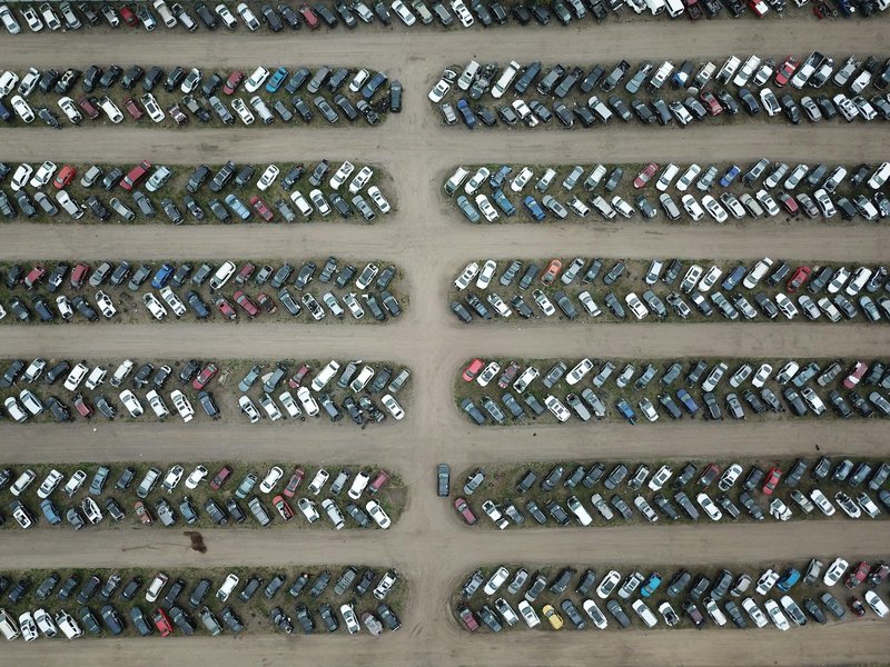 High angle view of numerous vehicles in an organized car lot, showcasing variety and structure.