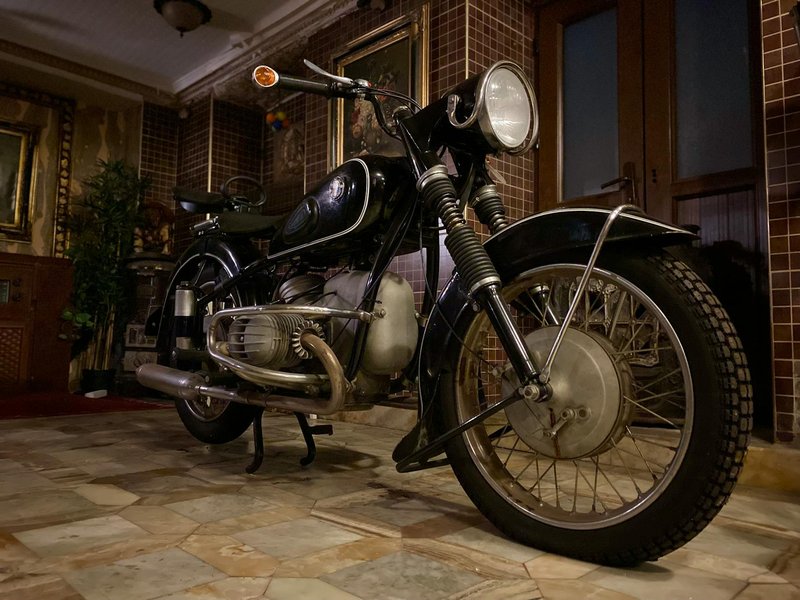 Classic motorcycle parked indoors with elegant decor, showcasing vintage design.