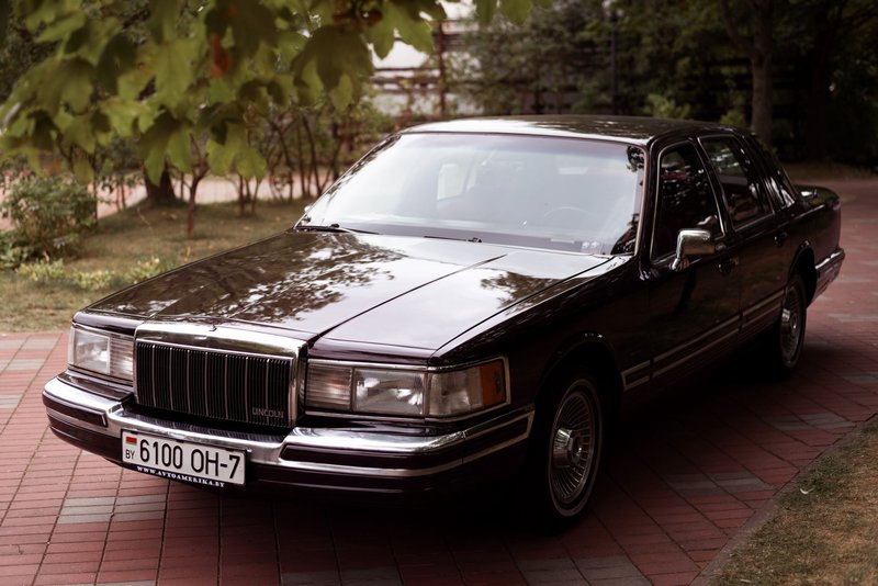 Classic 1992 Lincoln Town Car parked in a tree-lined driveway, capturing the essence of vintage automotive style.