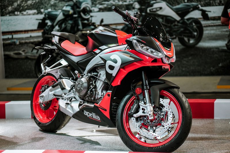 High-performance Aprilia motorcycle in striking black and red, showcased indoors.
