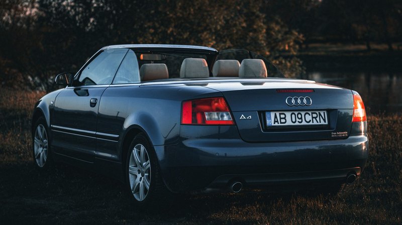 A sleek black Audi A4 convertible parked outdoors, perfect for wallpaper.