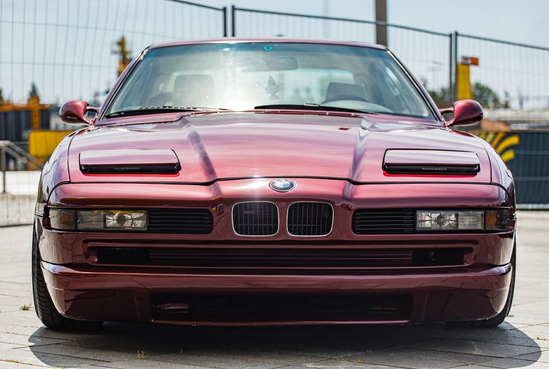Front view of a vintage red BMW sports car showcasing its timeless style and design.