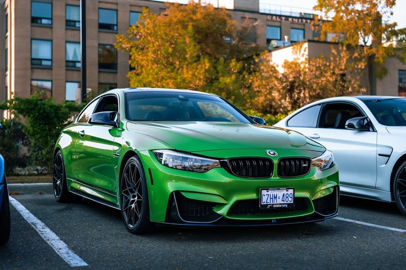 Stylish green BMW coupe parked brightly in an urban setting, ideal for automotive enthusiasts.