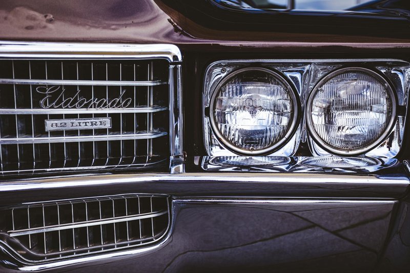 Detailed shot of a vintage Cadillac Eldorado headlight and grille, highlighting its classic design.
