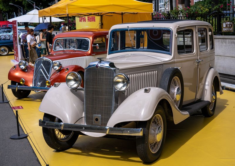 Showcase of classic vintage cars at an outdoor auto exhibition.