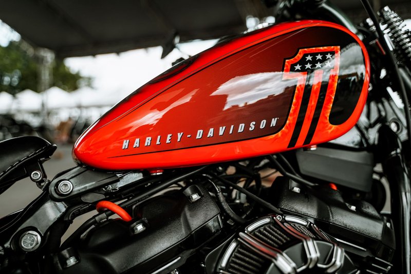 Close-up of a vibrant red Harley-Davidson motorcycle tank. Perfect for automotive enthusiasts.