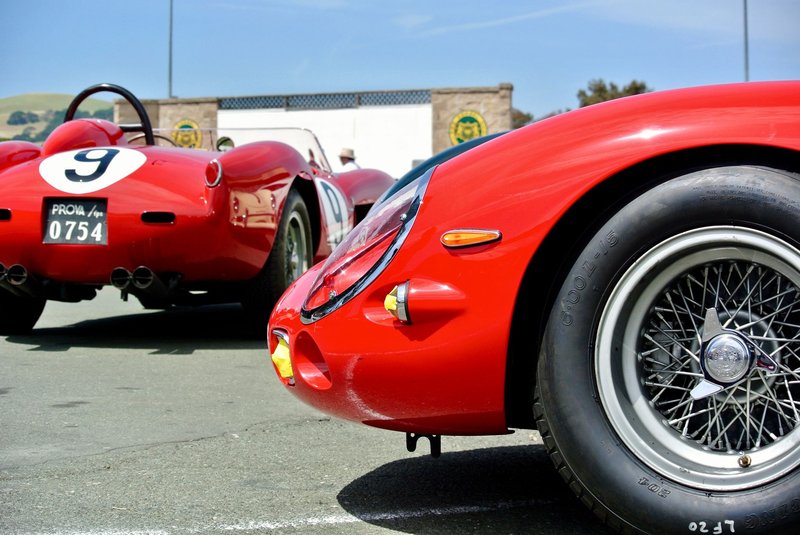 Vibrant red classic sports cars displayed at Sonoma Raceway under clear skies.