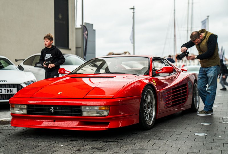 Vibrant red Ferrari Testarossa captured in a bustling street in Southampton, England.