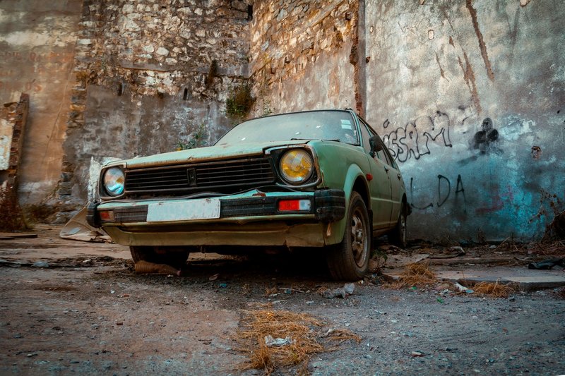 Explore the nostalgic charm of a rusty, vintage Honda Civic in an urban decay backdrop.