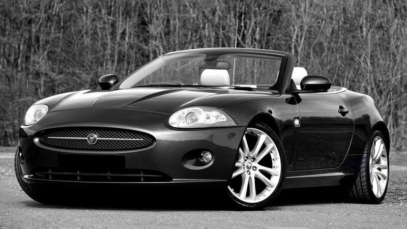Black convertible Jaguar sports car in a stylish outdoor setting.