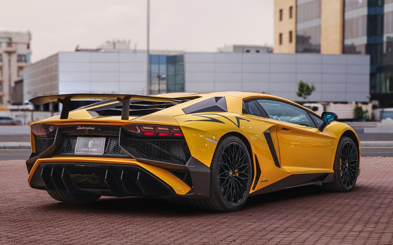 Sleek yellow Lamborghini Aventador parked on an urban street, showcasing luxury and performance.