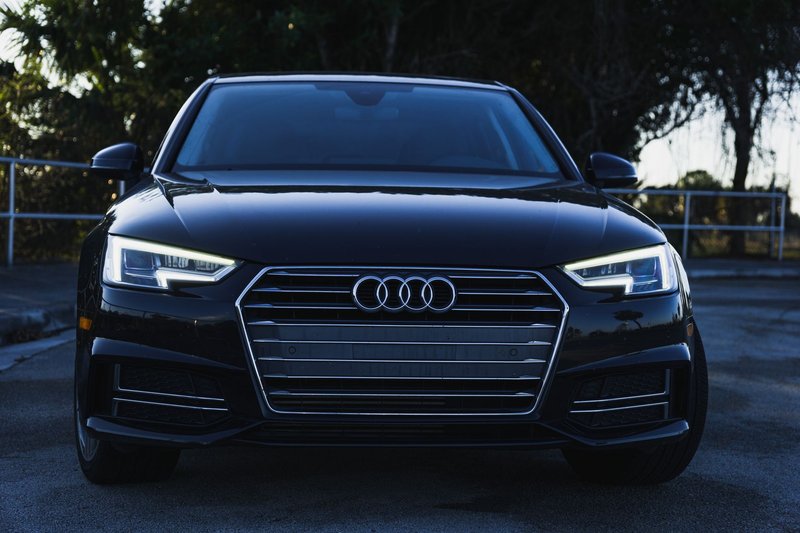 Contemporary black sedan with LED headlights in a parking lot setting.