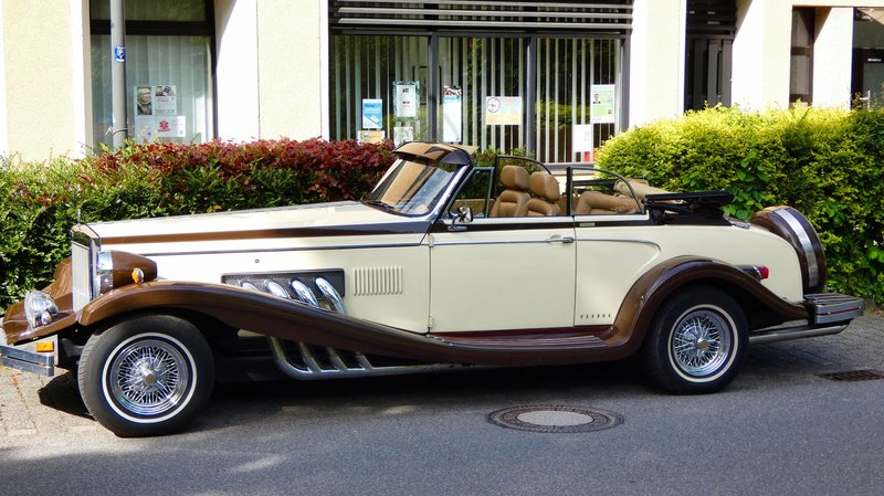 Classic vintage convertible car with chrome details parked outdoors.