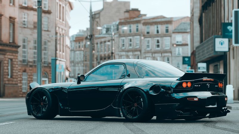 Sleek black Mazda RX7 sports car parked on a bustling urban street, showcasing luxury and style.