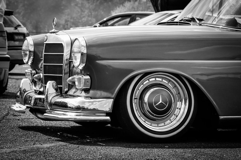 Close-up of a vintage Mercedes car in black and white, showcasing its iconic design.