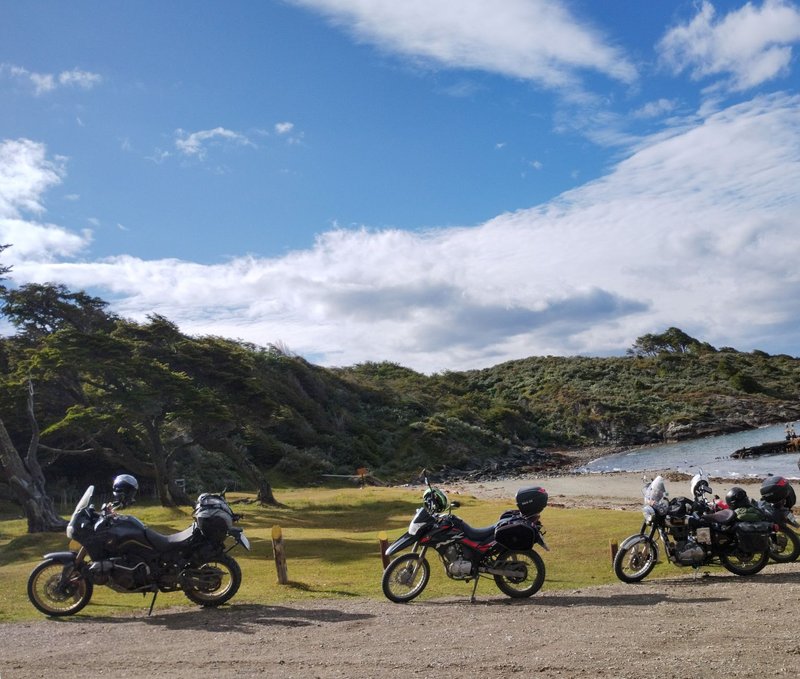 Scenic motorbike stop in Ushuaia, featuring rugged landscapes under a bright blue sky.