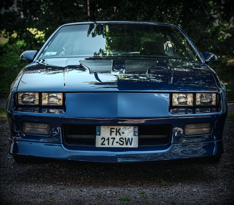 A classic blue Chevrolet Camaro 3rd generation parked outdoors, showcasing its vintage design.